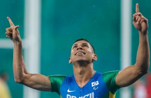 Mateus Evangelista com as duas mãos erguidas e aponta para o céu, em comemoração após a prova