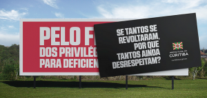 Outdoor de campanha na cor vermelha com texto em branco; na mensagem: Pelo fim dos direitos das pessoas co deficiência; sobre o anúncio, há um novo outdoor em preto, com texto em branco: se tantos se revoltaram, porque tantos ainda desrespeitam?; há ainda a bandeira e texto da Prefeitura de Curitiba, além do site da cidade: curitiba.pr.gov.br