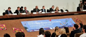Senadores estão na bancada diante do público que acompanha o seminário. Uma faixa traz o texto: Seminário Estatuto da Pessoa com Deficiência