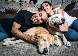 Genival e Kátia estão sorrindo, abraçados com seus cães-guias.