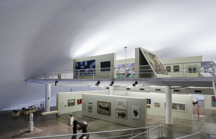Foto em plano aberto da exposição mostrando dois andares da Oca. No chão, há diversas esculturas e, nas paredes, quadros de tamanhos diversos