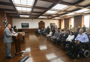 Em um salão fechado, o governo Geraldo Alckmin fala para público durante evento