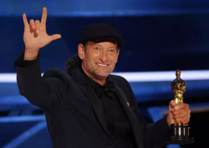 Foto do ator Troy Kotsur na cerimônia de premiação do Oscar 2022.