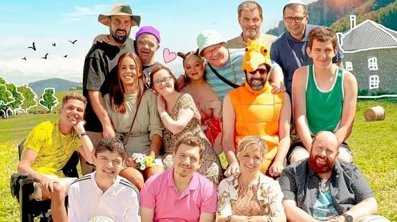 Grupo de pessoas diversas reunidas num campo verde e céu azul.