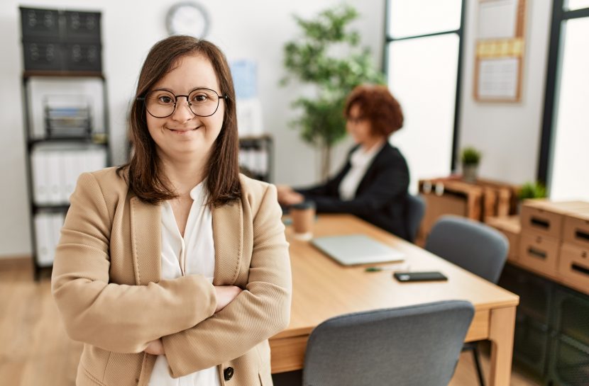 mulher com Down posando para foto em um escritório.