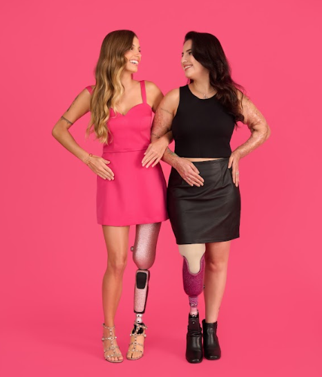 Paola Antonini e Kelen Ferreira posam lado a lado para foto. As duas se olham e sorriem